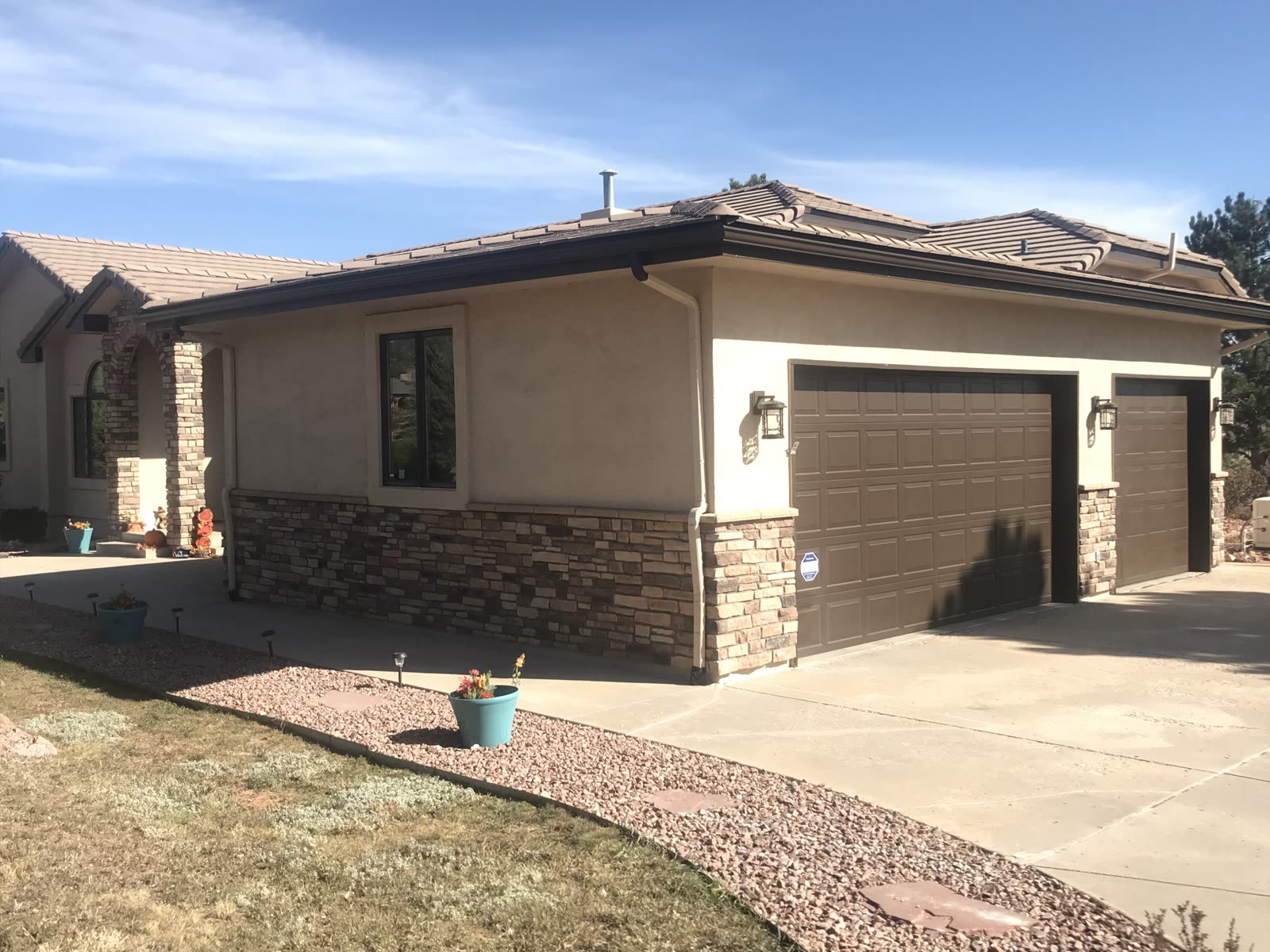 Single-story stucco home with stone-accent garage